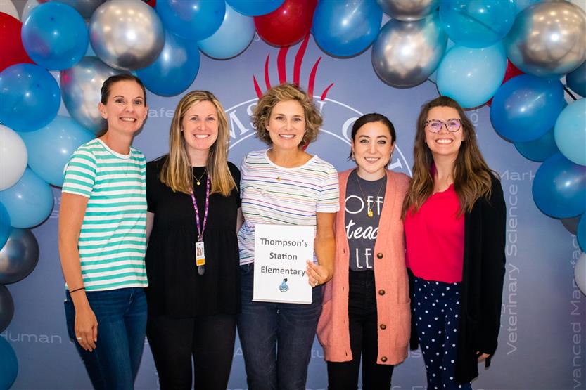 A group of teachers smile